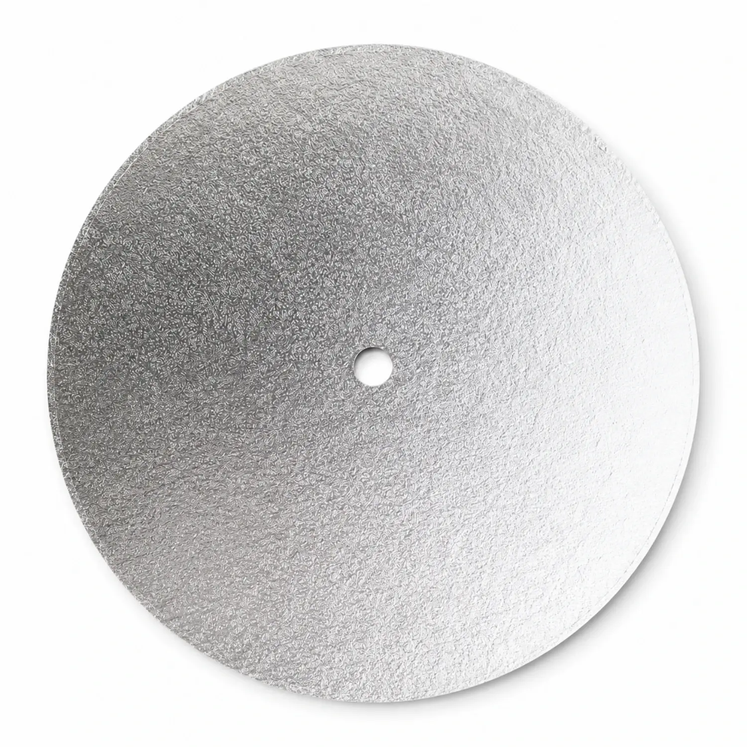 A round silver foil-wrapped cake drum seen from above, with the centre hole already cut