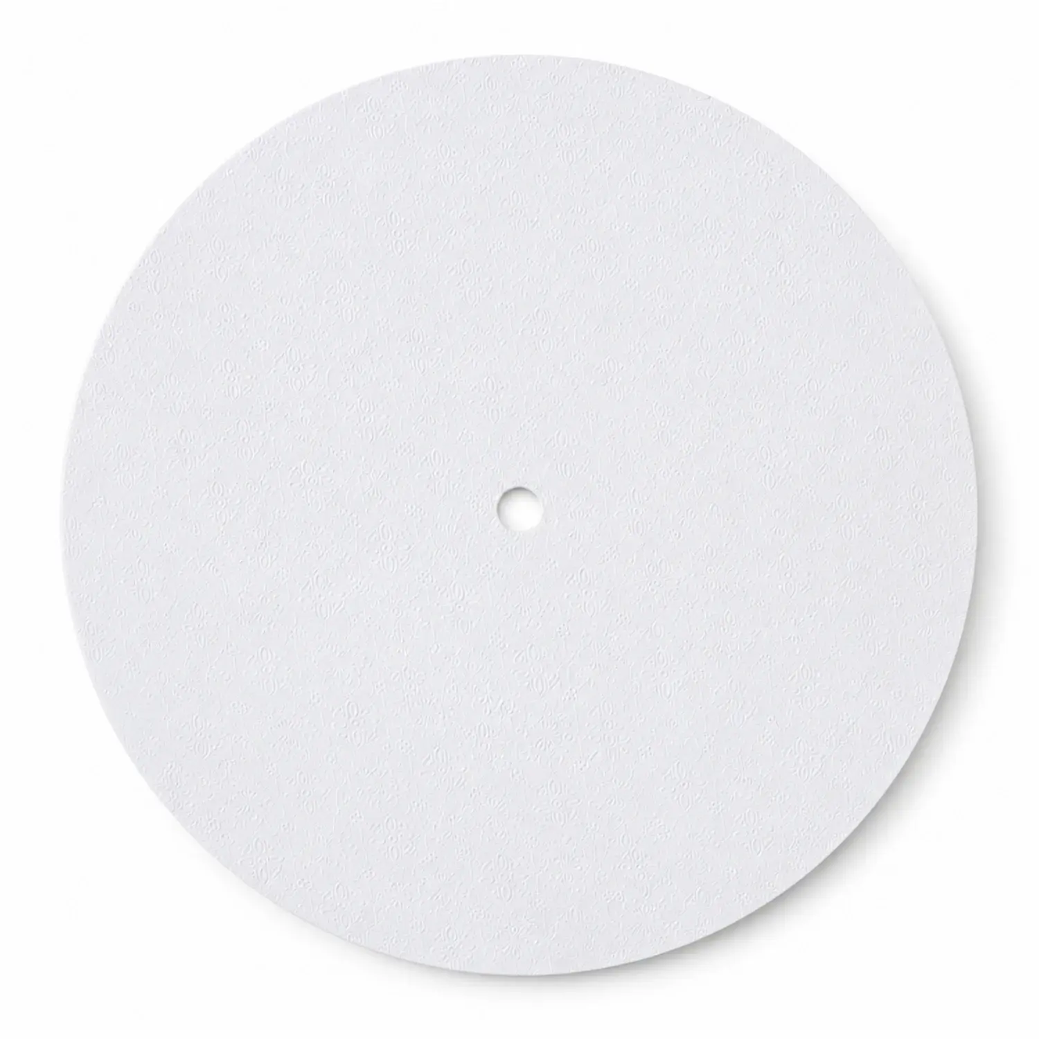 A round embossed white Masonite board seen from above, with the centre hole already cut